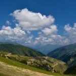 a scenic view of a valley with mountains in the background