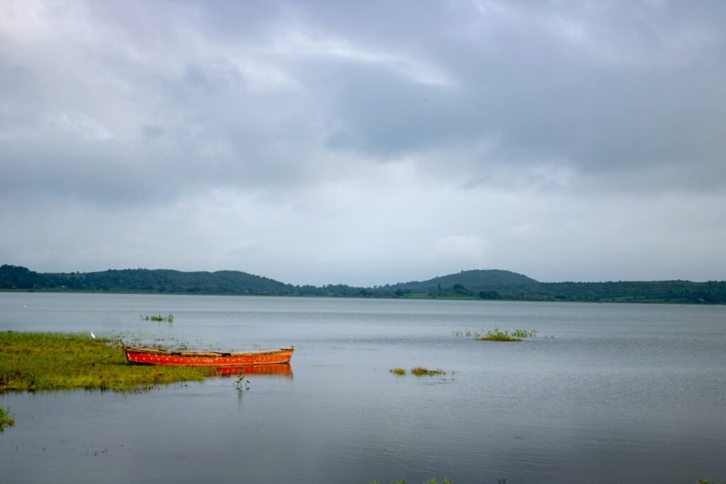 body of water near mountain under cloudy sky during daytime