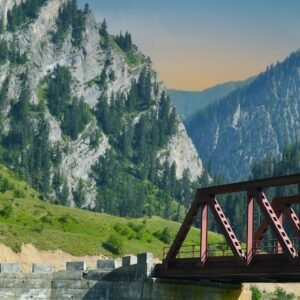 a bridge over a river with mountains in the background
