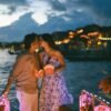 Couple kissing on a boat at night with lanterns.